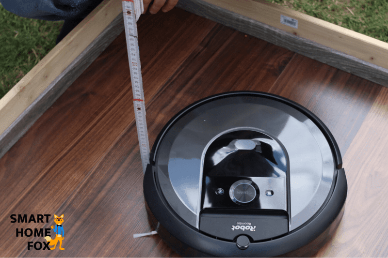 Высота iRobot Roomba i7 измеряется линейкой.